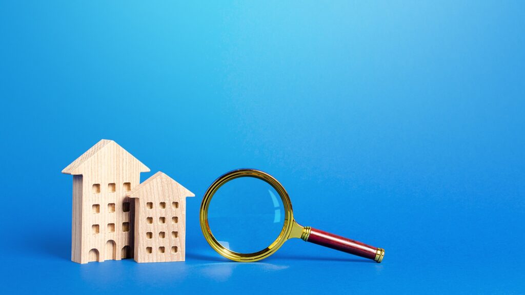 Wohngebäude und Vergrößerungsglas. Suche nach Immobilien zum Kauf. Langfristige und kurzfristige Vermietung von Wohnungen und Häusern. Dienstleistungen eines Maklers. Wichtige Dinge bei der Auswahl einer Immobilie.